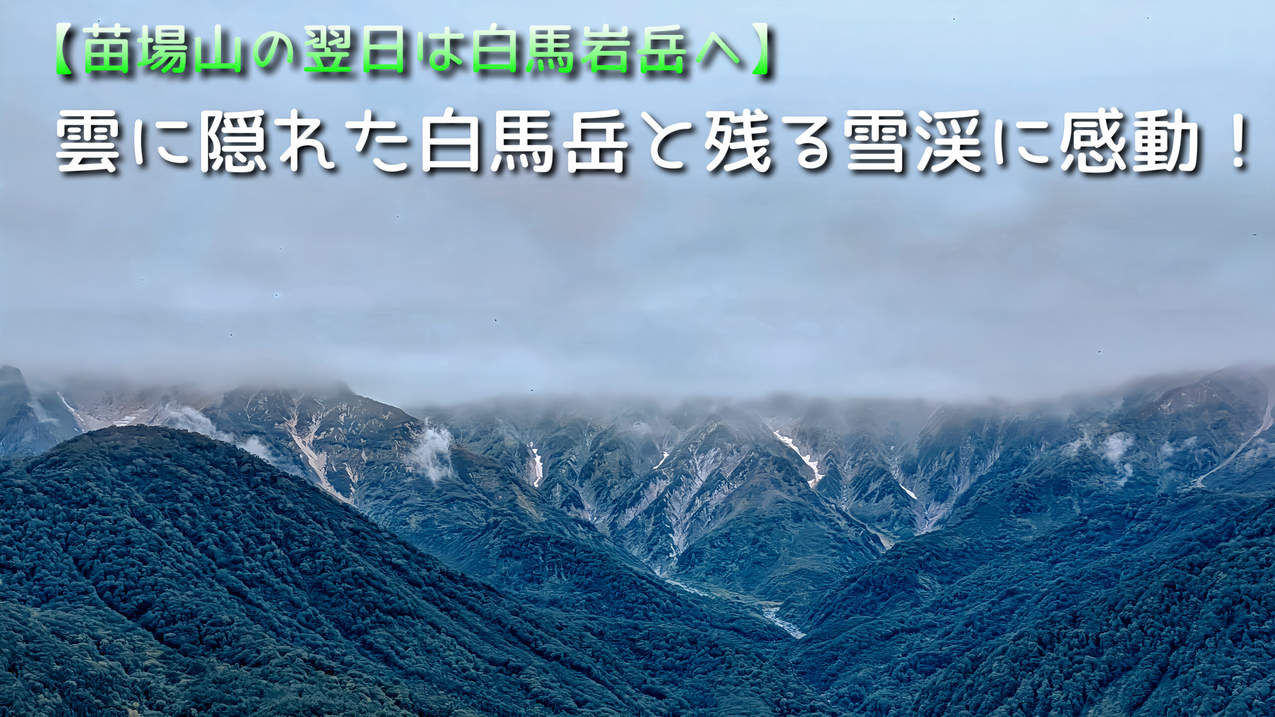 白馬岩岳から望む、山頂部が雲に覆われた白馬岳と谷筋に残る雪渓